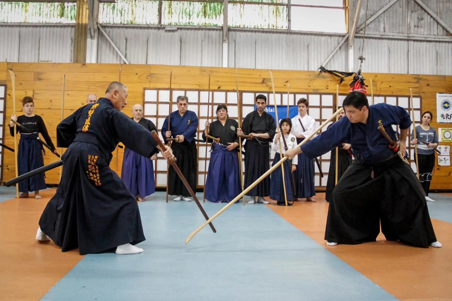 Sekiguchi sensei y un alumno en práctica de kumitachi, con público observando