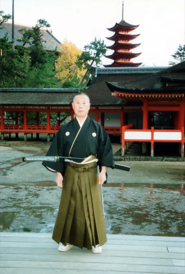Sekiguchi Takaaki Komei sensei con montsuki y katana frente al santuario de Itsukushima, Japón